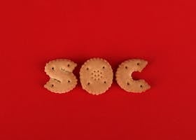 Letter-shaped cookies spelling SOC on a bright red background.