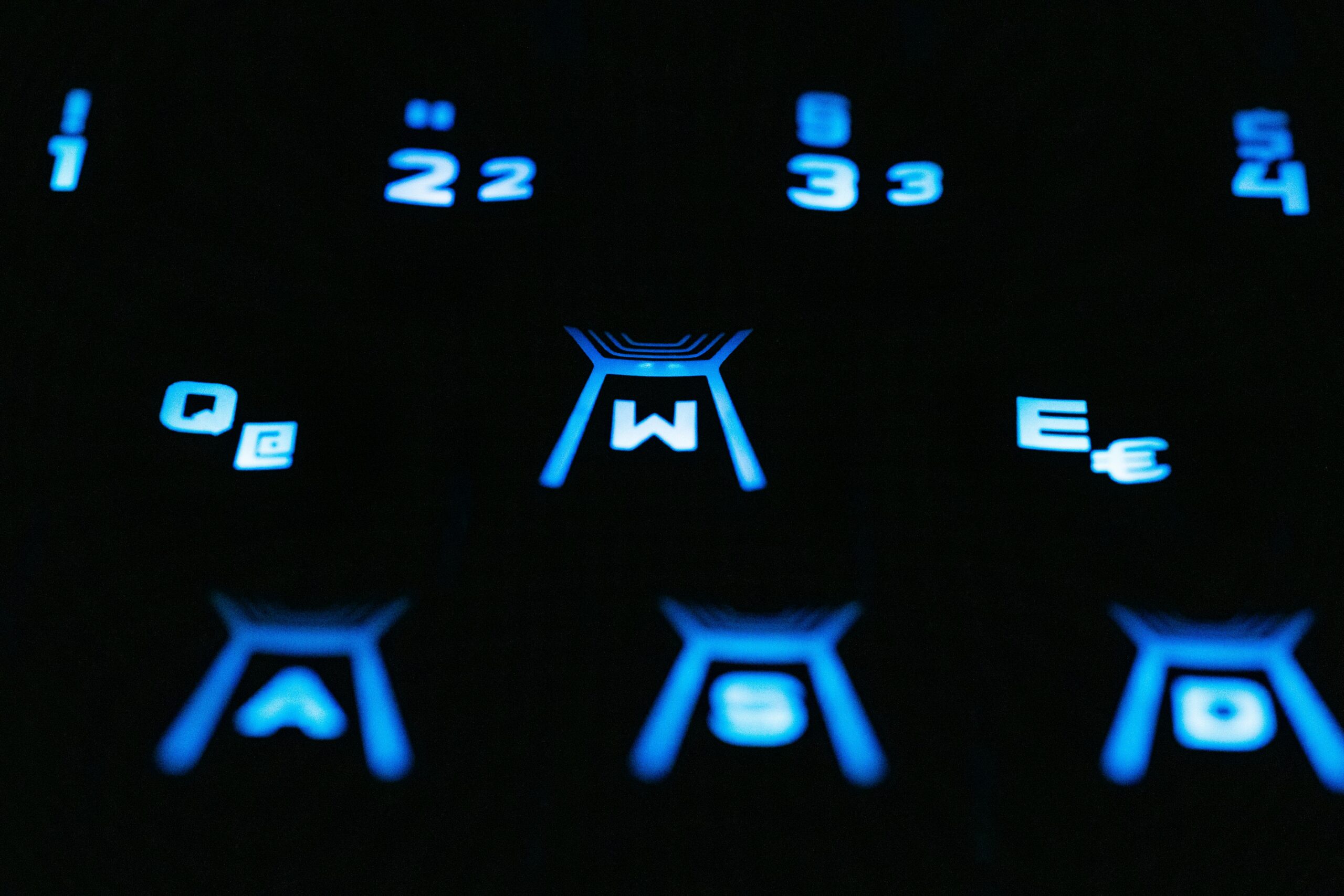 A closeup view of a blue backlit keyboard highlighting numbers and symbols.